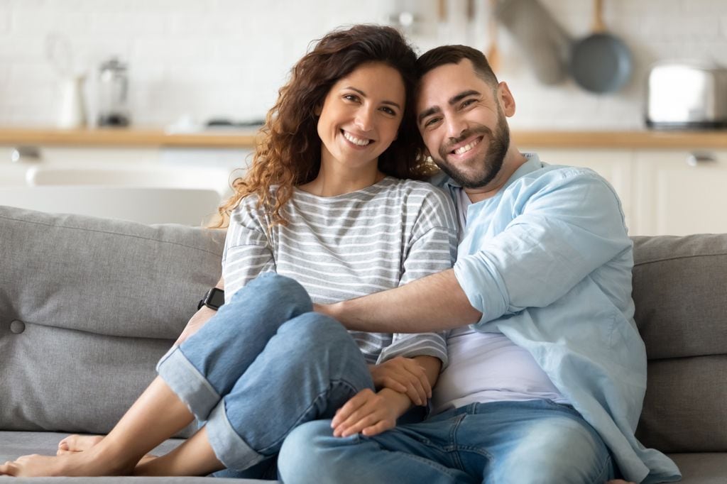 Pareja joven abrazados en el sofá