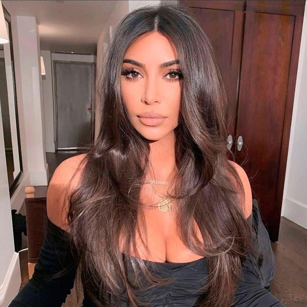 kim kardashian con cabello suelto ondas y raya en el medio