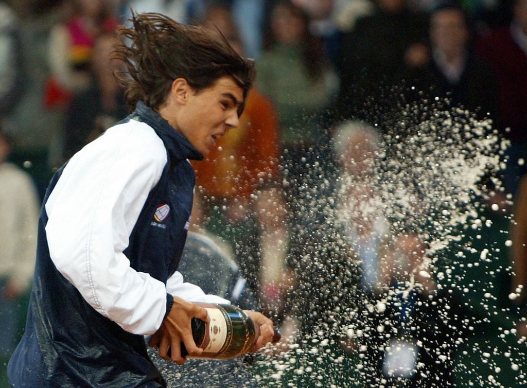 SEVILLE, Spain:  Rafael Nadal, the youngest Davis Cup winner in the history of the competition jubilates after World number five and 1998 French Open champion Carlos Moya of Spain won over World Number two Andy Roddick at the end of the Davis Cup final third single match, 05 December 2004 at La Cartuja Olympic stadium in Seville. Moya won 6-2, 7-6, 7-6 to give Spain  a 3-1 victory in the tie. Spain won his second ever Davis Cup title. AFP PHOTO CRISTINA QUICLER  (Photo credit should read CRISTINA QUICLER/AFP via Getty Images)