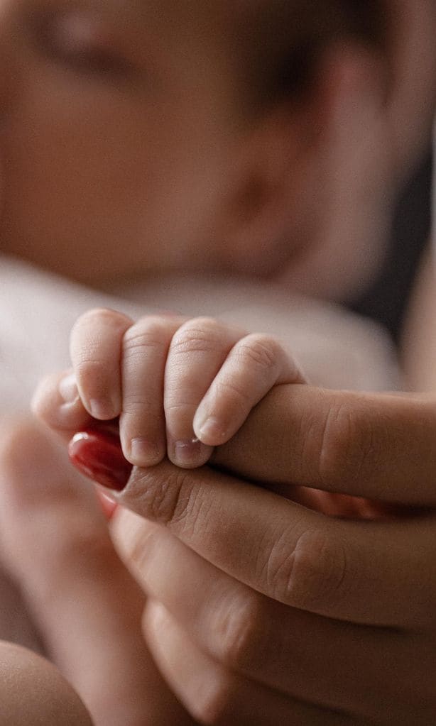 Mano de bebé con la de su mamá