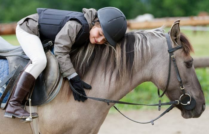 Niña abrazada al caballo