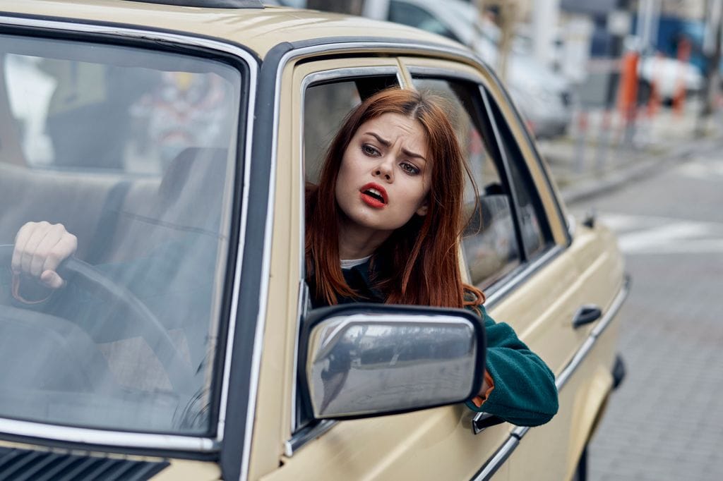 mujer enfadada dentro del coche, mientras conduce