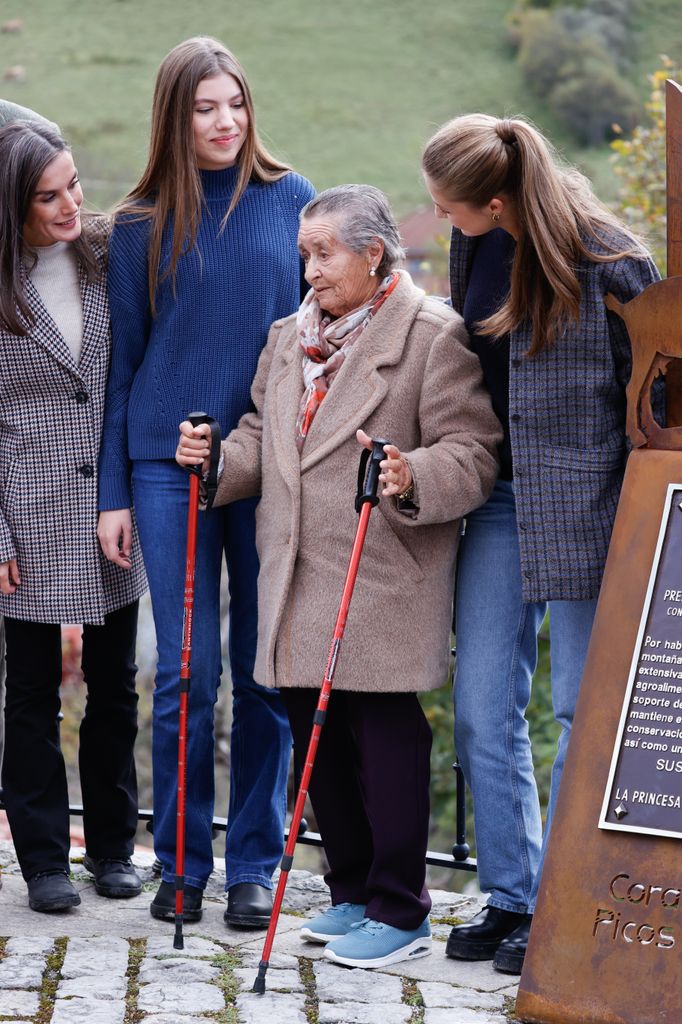 Familia Real posando en Sotres con una vecina de Sotres y con la Placa de Pueblo Ejemplat