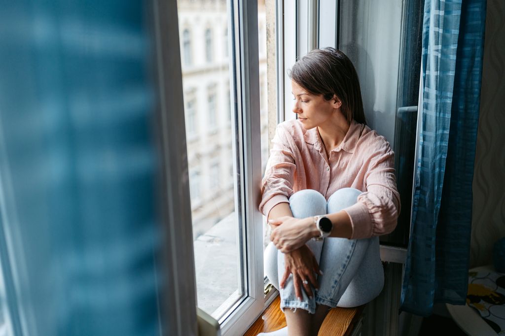 mujer relajada mirando por la ventana