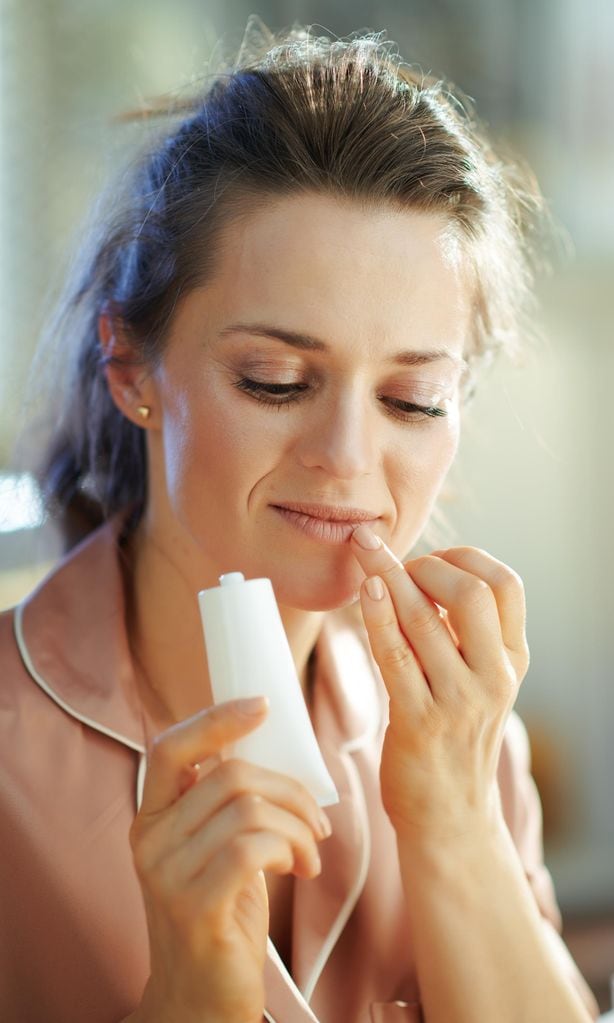 Mujer dándose crema en los labios