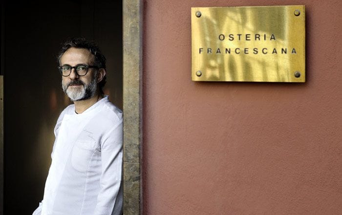 Bottura, en la puerta de su famoso restaurante, abierto en 1995. Con doce mesas y unas 30 plazas, este establecimiento cuenta también con el máximo reconocimiento de la Guía Michelin: sus tres codiciadas estrellas. Foto: Paolo Terzi.
