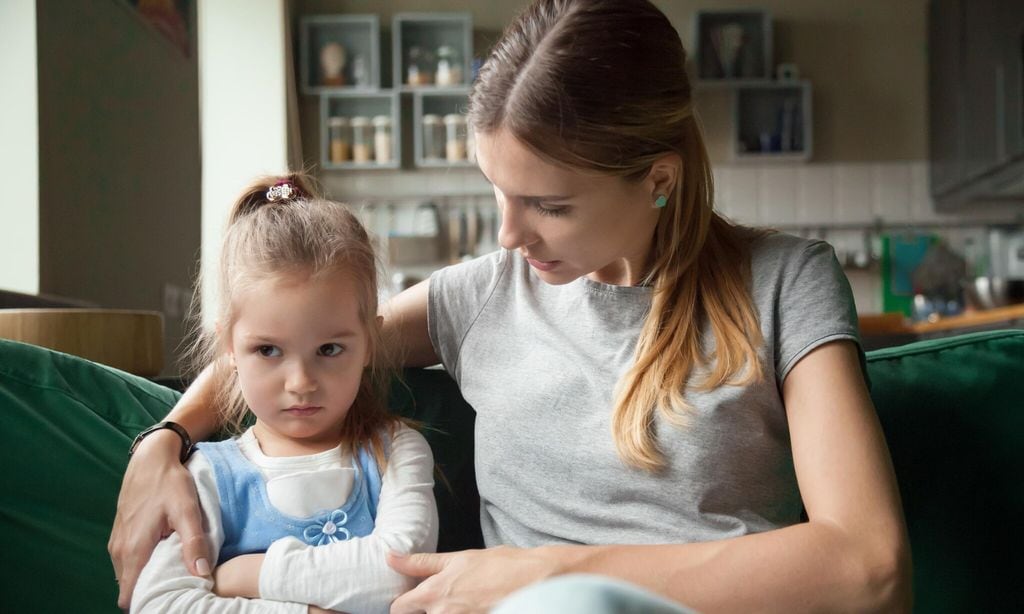 madre hablando con su hija enfadada en el sof 