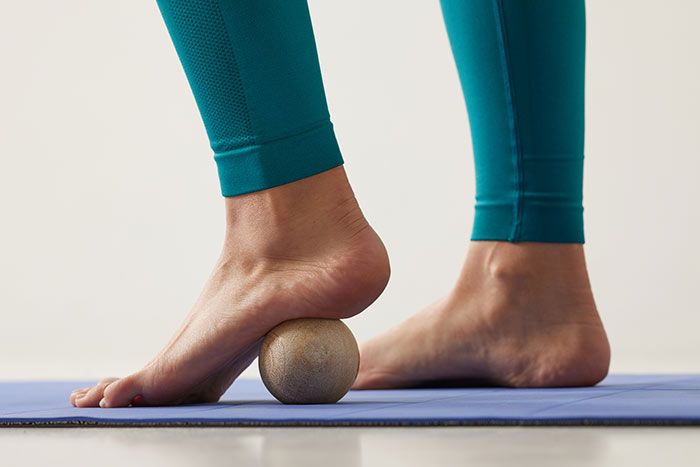 mujer relajando su pie con una pelota