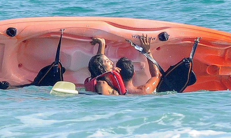 paz padilla y kike calleja tratando de levantar el kayak en el agua