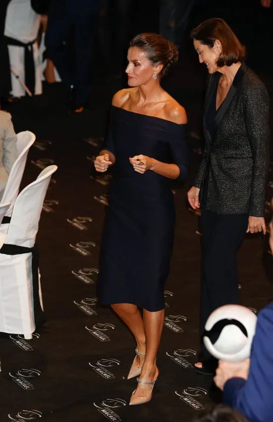 La reina Letizia recicla en Madrid su vestido negro de escote 'bardot' con zapatos de cristales
