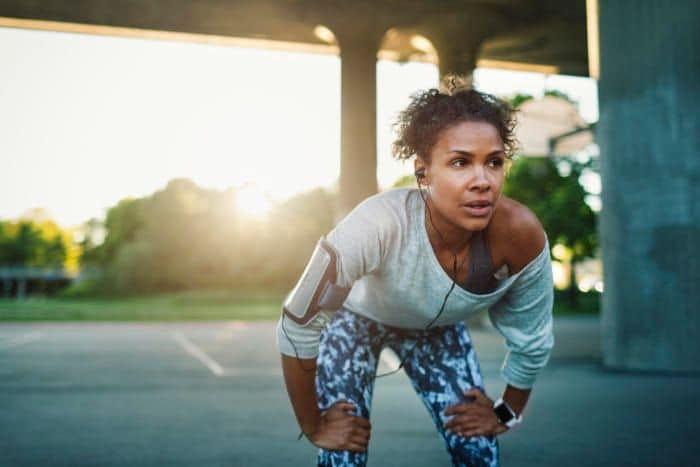 mujer descansando mientras hace deporte