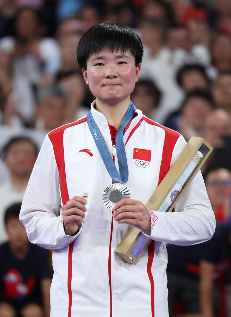 Bing Jiao He recogiendo la medalla de plata olímpica en bádminton