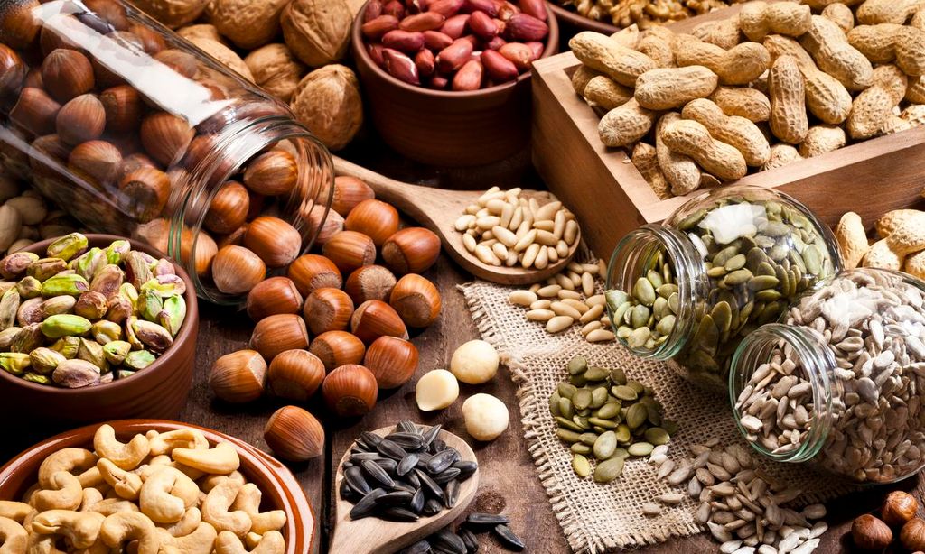 mesa con semillas y frutos secos ideales para una dieta saludable