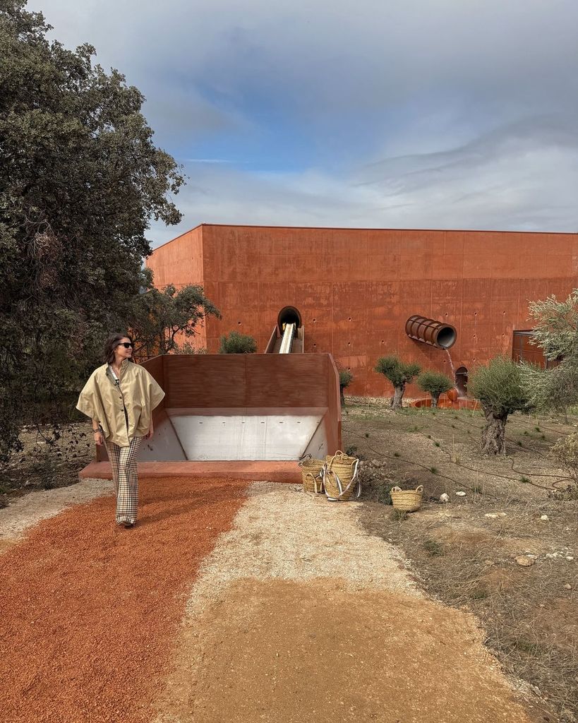 Isabelle Junot con mono de cuadros y gabardina en el campo