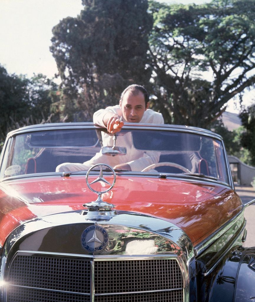 Reinaldo posando en su Mercedes rojo convertible de 1957