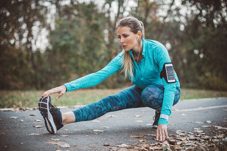 Mujer estirando después de hacer ejercicio en el parque