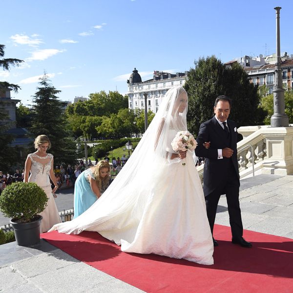 La novia estaba radiante con un vestido de elaborada falda y cuerpo sin mangas con transparencias y pedrería. Llevaba el pelo recogido en un elegante moño cubierto por un velo
