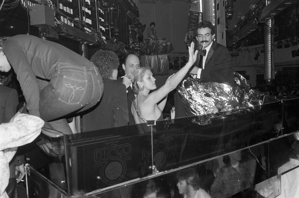 Carolina Herrera saluda a la multitud junto a Reinaldo Herrera y Victor Hugo durante la fiesta de Año Nuevo en Studio 54, Nueva York, el 1 de enero de 1979