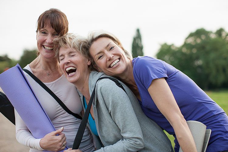 Mujeres maduras sonriendo divertidas después de hacer ejercicio