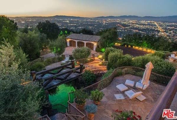 En el exterior de la casa, todo lujo de detalles: piscina climatizada, un bonito puente peatonal y mucha vegetación. La propiedad dispone de 2.000 metros cuadrados y tiene unas preciosas vistas al valle de San Fernando © The MLS
