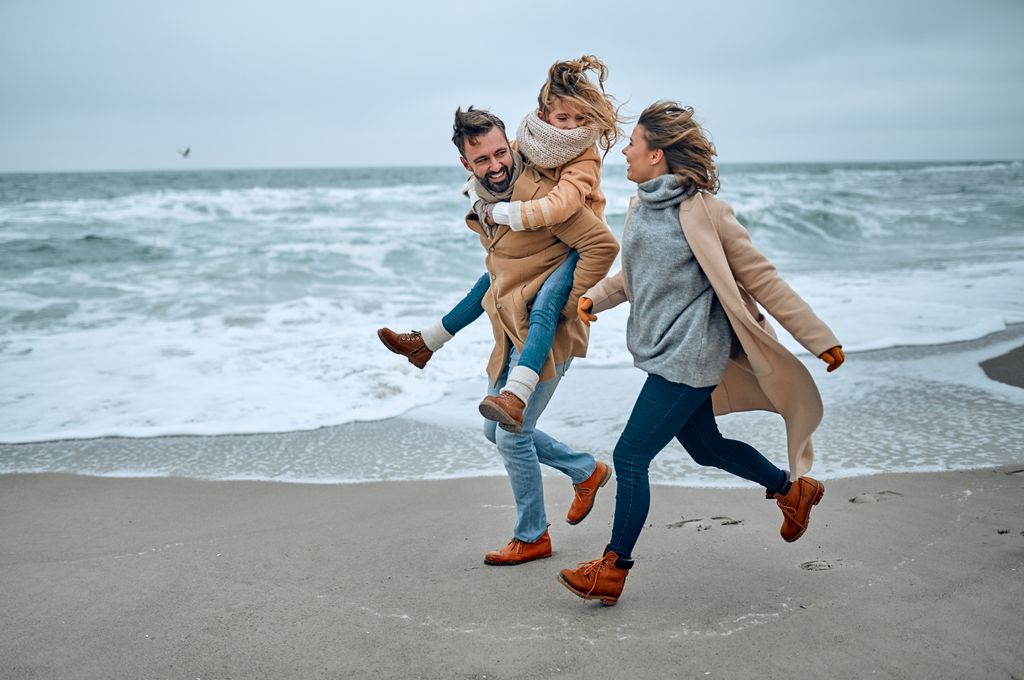 Padres con su hija en la playa en invierno