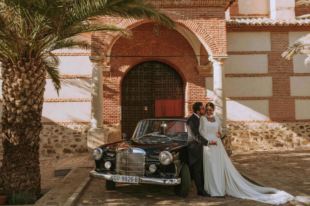 Pareja de novios junto a coche