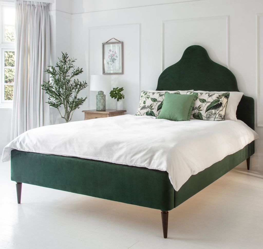 Dormitorio decorado en blanco con cama verde