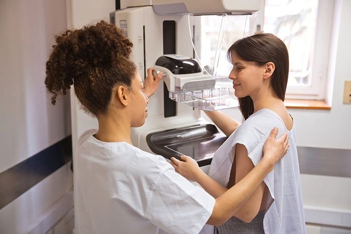 Mujer joven haciéndose una mamografía