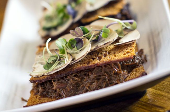 La casquería se reinventa en 'La Tasquería' de la mano del chef Javier Estévez, dando lugar a recetas tan apetecibles como las de la imagen. De arriba abajo y de izquierda a derecha: Sándwich de carrillera; Manitas con alcachofa y cigala; Morro con encurtidos y anchoa; y Rabitos de cerdo con anguila y queso.
