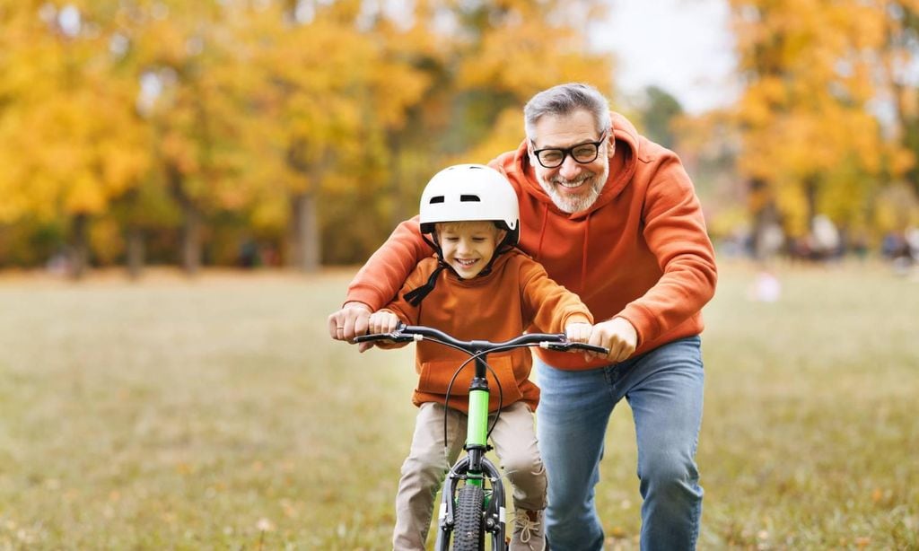 padre e hijo en el parque ense andole al ni o a montar en bicicleta