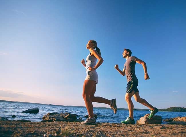 pareja practicando running junto al mar