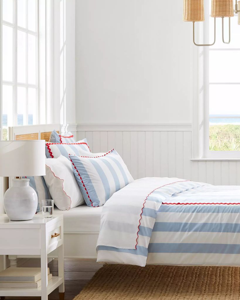 Dormitorio blanco con colcha de rayas azules