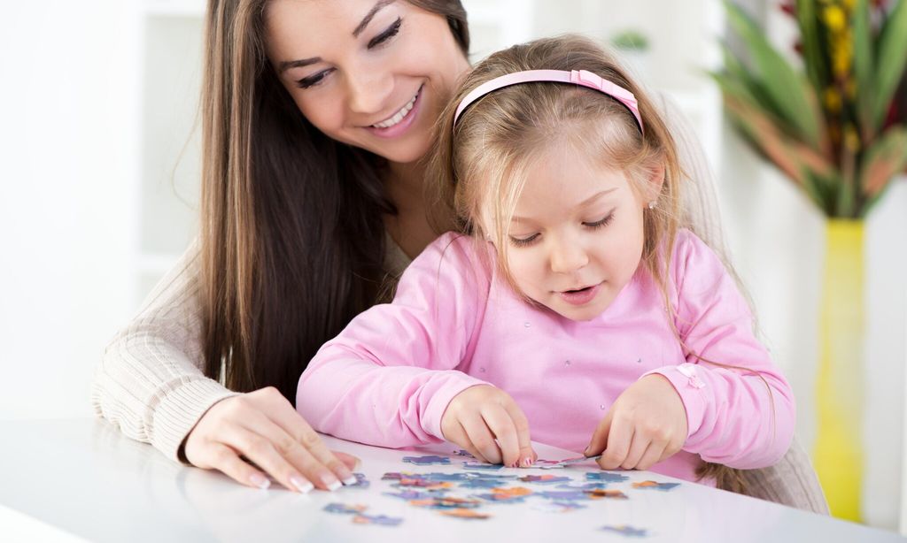 a mother and her daughter solving a puzzle together