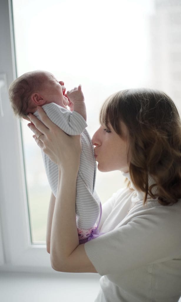 Mamá dando un beso en la barriga de su bebé