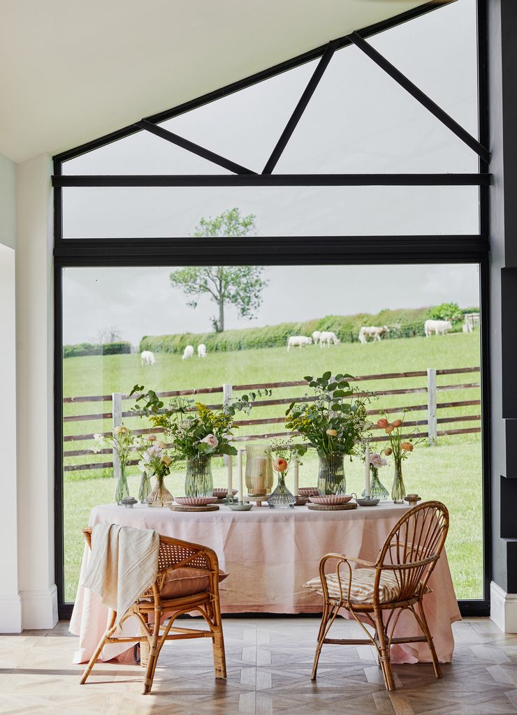 Comedor vintage con sillas de mimbre y mantel blanco. 