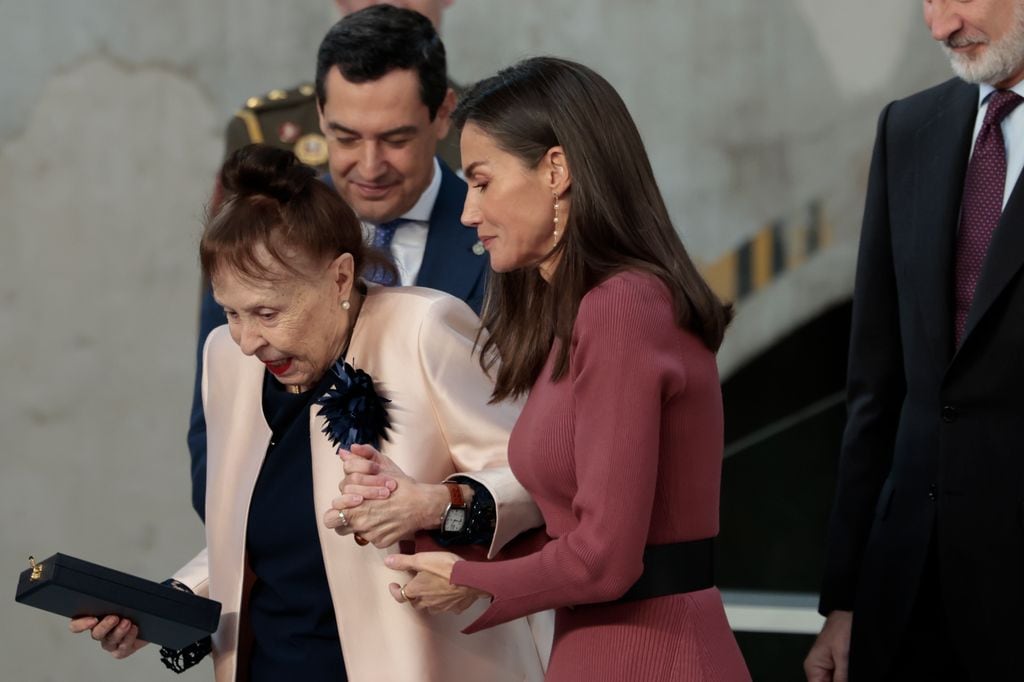 La reina Letizia ayuda a Gemma Cuervo a bajar del escenario tras entregarle la Medalla de Oro a las Bellas Artes