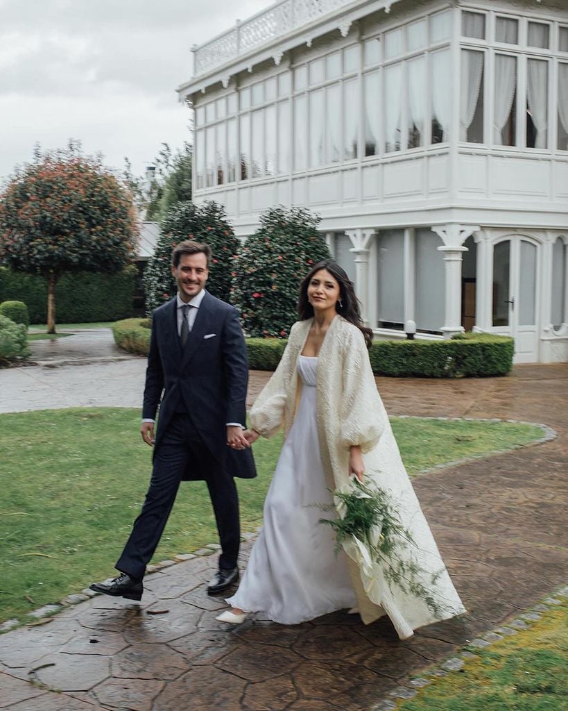 Look de novia con abrigo con volumen para bodas de invierno