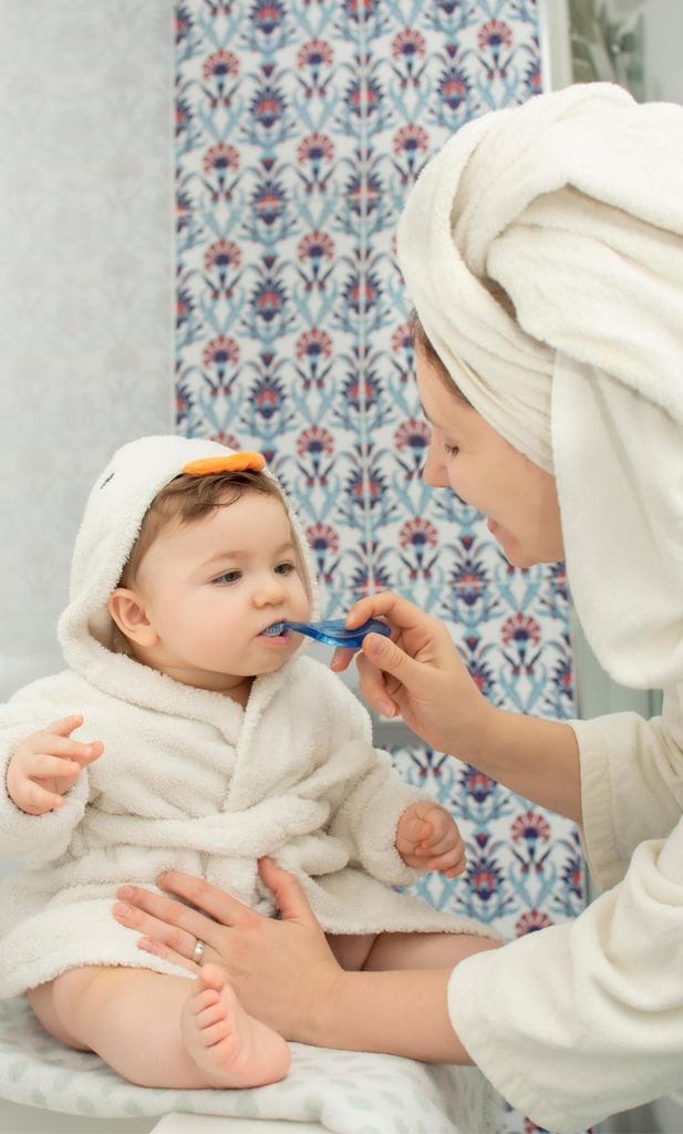 Mamá cepillando los dientes a su bebé