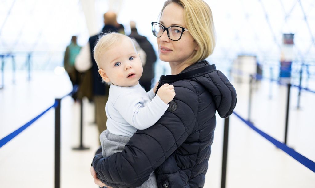 Madre con su bebé en brazos en el aeropuerto