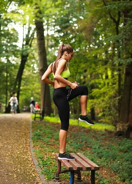 mujer haciendo ejercicio en un banco del parque