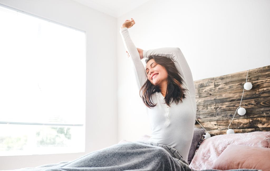 Mujer en la cama feliz de dormir bien