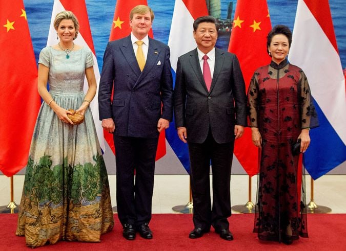 La Reina ha lucido un vestido del diseñador holandés Mattijs van Bergen, con un estampado basado en la pintura Olivos con cielo amarilo y sol de Vincent van Gogh. En la foto junto a su marido, el rey Guillermo Alejandro; el Presidente chino, Xi Jinping; y la Primera Dama, Peng Liyuan
