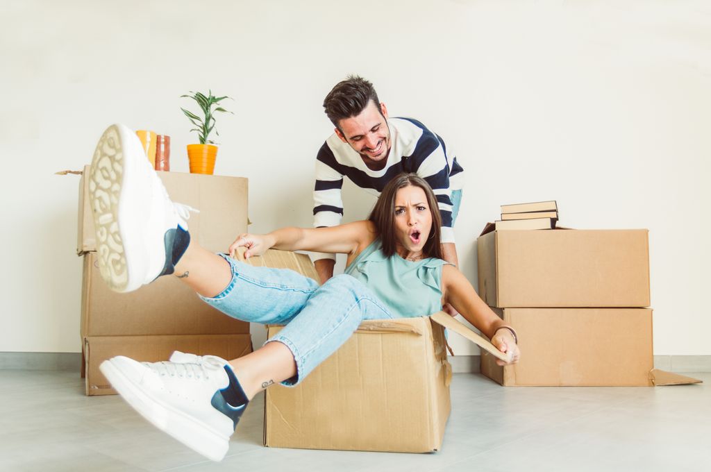 pareja feliz rodeada de cajas de mudanza