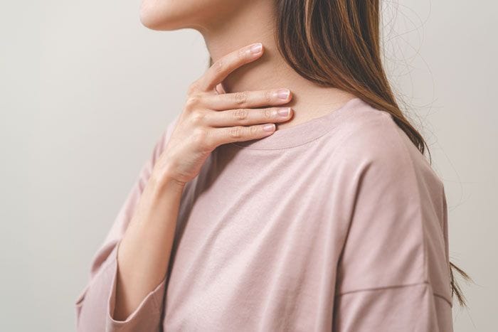 mujer tocándose el cuello