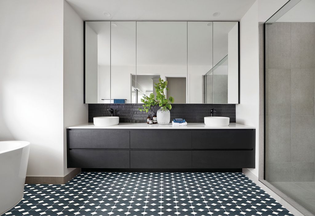 Baño con suelo de damero blanco y negro, dos lavabos redondos, espejo XL y mueble negro