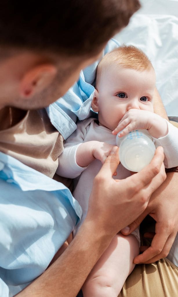 Papá dando biberón a su bebé