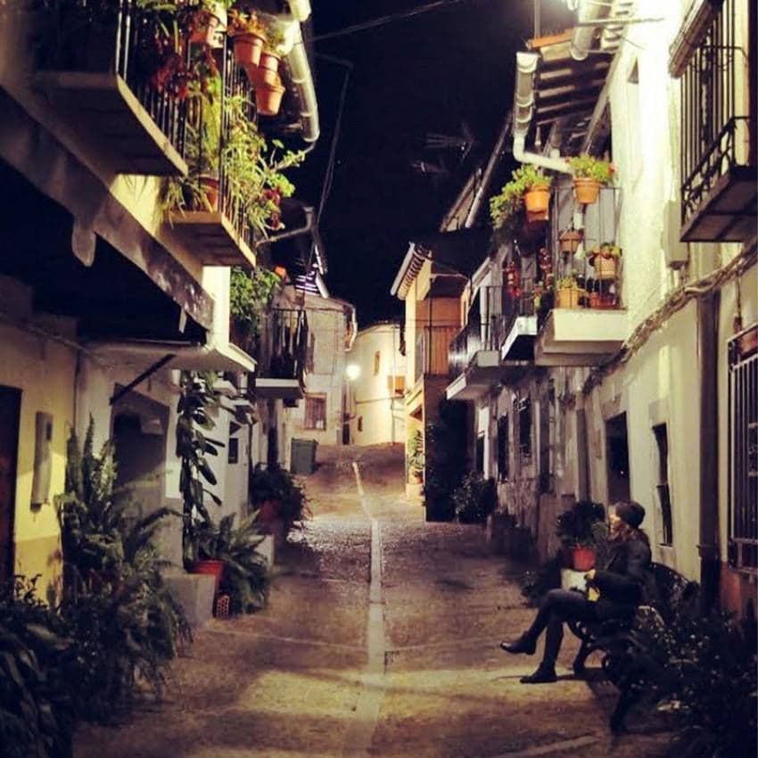 Calles empedradas y casas con balconadas repletas de macetas.