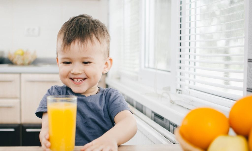 ni o con vaso de zumo de naranja