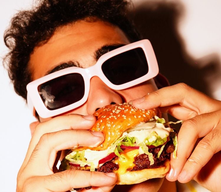 Chico joven comiendo una 'smash burger'