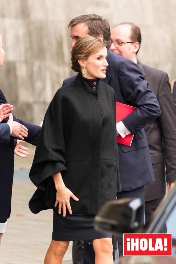 Para hacer frente al frío alemán, doña Letizia optó por estrenar original capa, también de Hugo Boss. Completaba su 'look' con unos 'stilettos' negros de Prada, un bolso negro de Hugo Boss y unos espectaculares pendientes de plata cubiertos de oro champán con piedras naturales de amatista verde de la firma Colook
